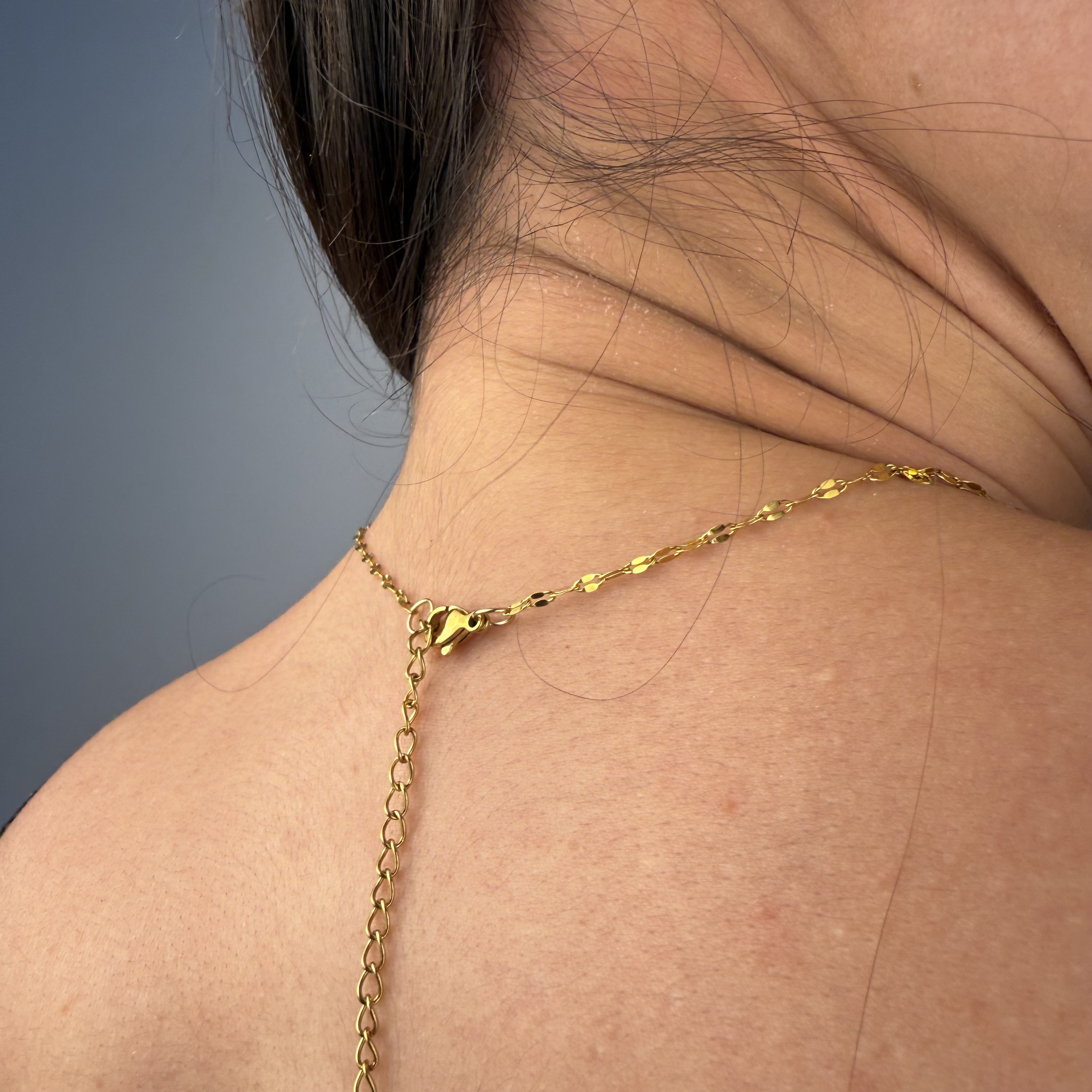 Delicate gold tone birth flower pendant necklace in stainless steel, handcrafted dainty charm necklace for everyday wear.