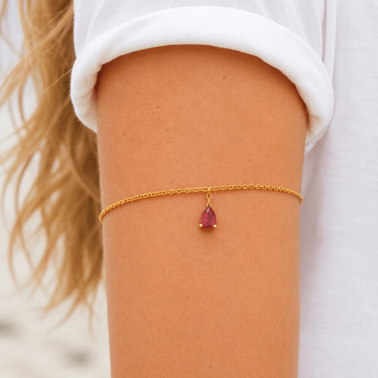 Dainty single-strand gold stainless steel birthstone arm band with teardrop gemstone, waterproof upper arm jewelry