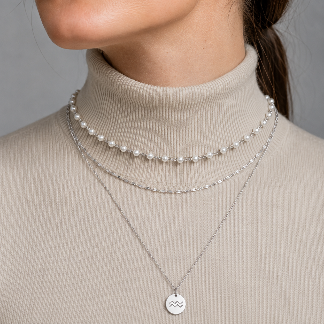Curated layered necklace stack with pearl bead choker, cable chain, and zodiac pendant necklace in waterproof gold or silver stainless steel