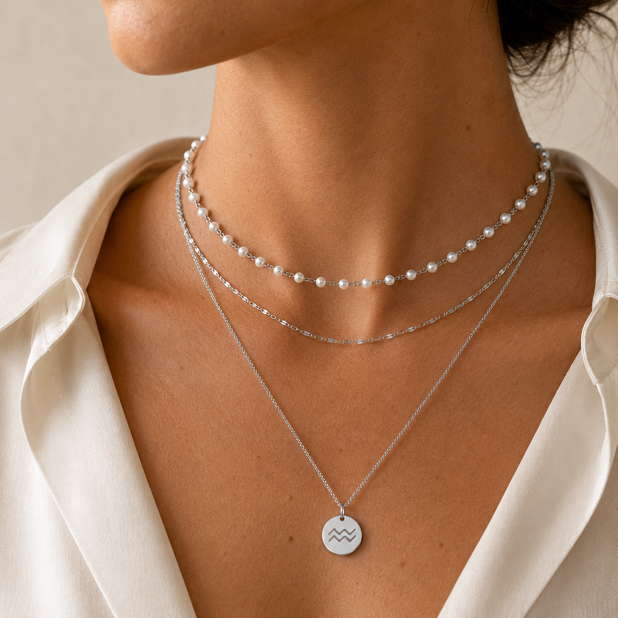 Curated layered necklace stack with pearl bead choker, cable chain, and zodiac pendant necklace in waterproof gold or silver stainless steel