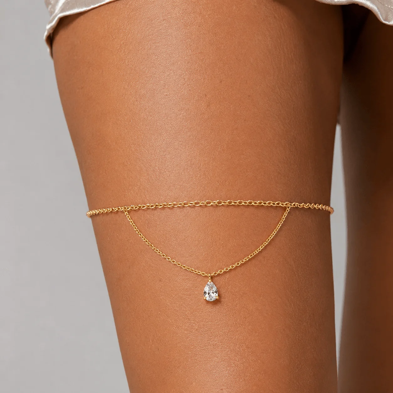 Gold-tone stainless steel birthstone thigh chain with delicate gemstone drop for unique leg jewelry